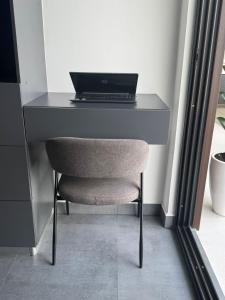 a desk with a laptop on top of it with a chair at Ocean Dream Apartment E2-A4 in San Juan del Sur