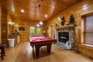 a pool table in a room with a fireplace at Mountain Sunrise by Avada Properties in Sevierville