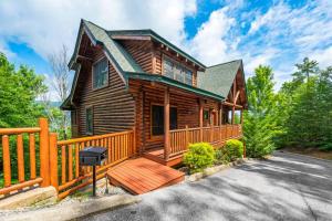 a log cabin with a deck and a fence at Mountain Sunrise by Avada Properties in Sevierville