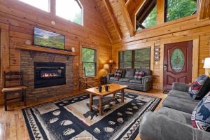 a living room with a fireplace in a log cabin at Mountain Sunrise by Avada Properties in Sevierville