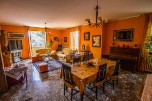 sala de estar con paredes de color naranja, mesa y sillas en B&B I Narcisi, en Spello