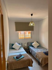 a room with two beds and a window at Apartamento Parque del Duque in Orihuela Costa