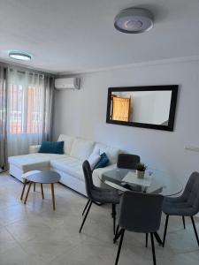 a living room with a white couch and a table at Apartamento Parque del Duque in Orihuela Costa