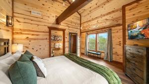 a bedroom with a large bed in a log cabin at Jericho Way- luxe retreat indoor pool theater room in Sevierville