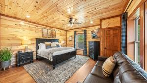 a bedroom with a bed and a couch in a log cabin at Jericho Way- luxe retreat indoor pool theater room in Sevierville +42 photos