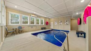 a swimming pool in a room with a table and chairs at Jericho Way- luxe retreat indoor pool theater room in Sevierville