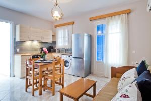 a kitchen and living room with a table and a refrigerator at Pleiades Apartments in Lefkos Karpathou