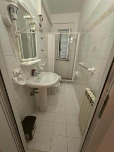 a white bathroom with a sink and a mirror at Villa Antonio in Forio d'Ischia +22 photos