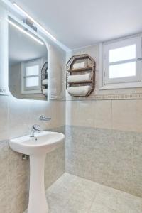 a bathroom with a sink and a mirror at Pleiades Apartments in Lefkos Karpathou