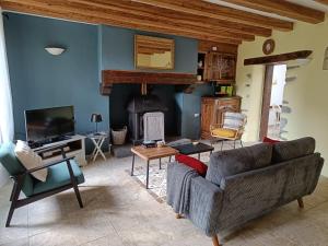 a living room with a couch and a fireplace at Gite Petite Florence in Châteauneuf-du-Faou