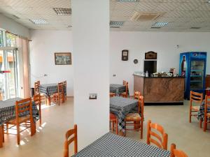 a dining room with tables and chairs and a counter at Hotel & Restorant Vjosa in Tepelenë
