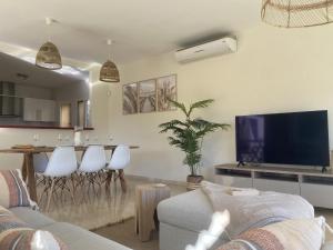 ein Wohnzimmer mit einer Couch, einem Fernseher und einem Tisch in der Unterkunft Casa la Riviera del Sol in Mijas Costa