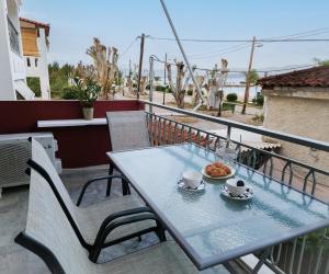 a table and chairs on the balcony of a house at Mare Vento in Kiveri