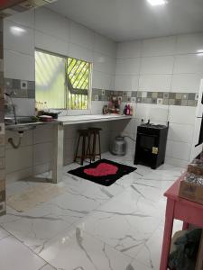 eine Küche mit weißen Fliesenböden und einer Arbeitsplatte in der Unterkunft Casa na ilha do combu in Acará