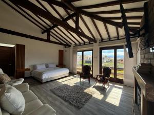 1 dormitorio con 1 cama y sala de estar con ventanas en MONTEVERDI De LUXURY, en Villa de Leyva