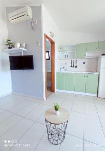 a kitchen with green cabinets and a small table at Kids Friendly Seaside Apartments Grebaštica - Šibenik in Grebaštica +11 photos