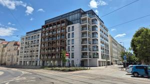 an apartment building on a city street with a car at Luxurious Cinnamon Apartment, self check-in 24h, free parking, air-conditioning in Poznań