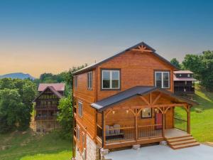 an image of a house with a wrap around porch at Misty Mountain Stop by Avada Properties in Pigeon Forge