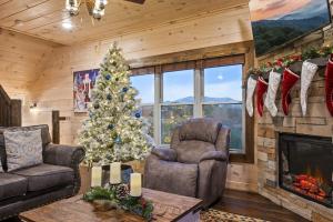 a living room with a christmas tree and a fireplace at Misty Mountain Stop by Avada Properties in Pigeon Forge