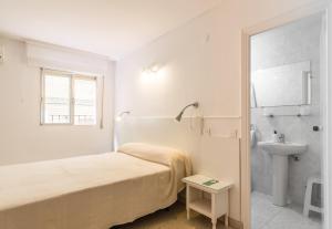 a white bedroom with a bed and a sink at Hostal Altamar in Almuñécar +66 photos