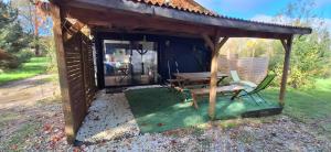 einem Holzpavillon mit einem Tisch und einer Bank in der Unterkunft Gîte Nature sur LAC avec accès PISCINE et PONTON in Éguzon-Chantôme + 5 Fotos