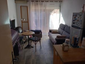 a living room with a couch and a table at Le CENTAURE Proche Centre Naturiste in Cap d'Agde