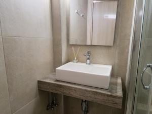 a bathroom with a white sink and a mirror at Mare Vento in Kiveri