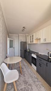 una cucina con tavolo, tavolo e sedie di Жана кала 1 комнатная квартира a Türkistan