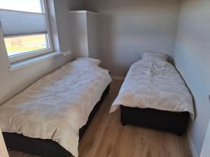 two beds in a small bedroom with a window at holiday home Nuil in Pesse