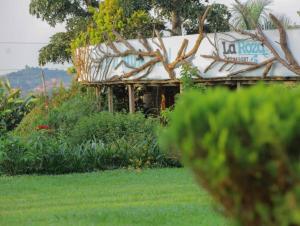 an old house in a yard with a tree at La Roza Resort Masaka in Masaka