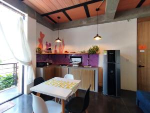 a kitchen with a table and chairs and a refrigerator at Hellen House Bello Horizonte in Santa Marta