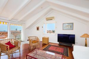 a living room with a tv and a couch and chairs at Luxury Villa In the Old Town with Stunning Views in Dubrovnik