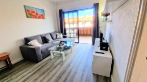a living room with a couch and a table at Cozy Apartment Tenerife South Wifi & Pool in Costa Del Silencio