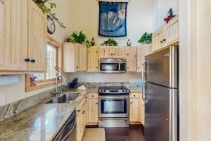 Una cocina con gabinetes de madera y un refrigerador de acero inoxidable. en Harris House, en Breckenridge