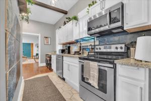 a kitchen with stainless steel appliances and white cabinets at Serenity House 2BR Central Location in ATL in Atlanta