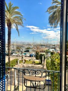 a balcony with a table and palm trees and a harbor at Entire Flat First Beach line - Sea Views - Vilanova i Geltru in Vilanova i la Geltrú