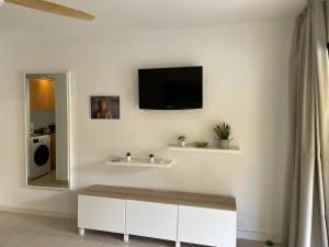 a living room with a tv on a white wall at Paraíso Lulú in La Oliva