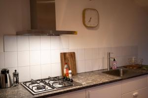 a kitchen with a stove and a sink and a clock at Rancho Bejarano in Kollumerpomp