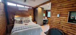 a bedroom with a bed in a wooden wall at Windsong Living The Nest in Krugersdorp