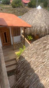 a small hut with a thatched roof and a porch at Cabaña El Cangrejo Azul - Blue Crab House in San Onofre