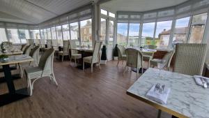 a dining room with tables and chairs and windows at South Beach Hotel in Troon
