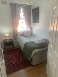 a small bedroom with a bed and a window at Sleeps 7 Home Blackpool w Free Parking BBq WiFi in Blackpool