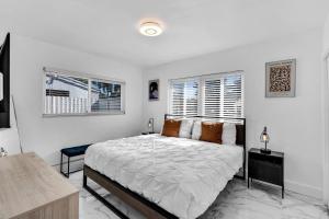 ein weißes Schlafzimmer mit einem Bett und zwei Fenstern in der Unterkunft Relax & Fun Hollywood Private Pool | Arcade Game in Hollywood + 37 Fotos