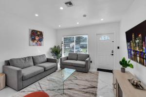 ein Wohnzimmer mit Sofa und Tisch in der Unterkunft Relax & Fun Hollywood Private Pool | Arcade Game in Hollywood