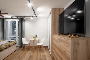 1 dormitorio con TV y mesa con sillas en Nowy Świat Suite, en Wroclaw