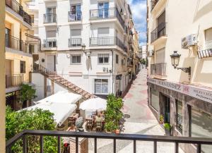 a street in a city with tables and umbrellas at Hostal Altamar in Almuñécar
