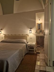 a bedroom with a bed and a mirror on the wall at Residenza Storella 18 in Alessano