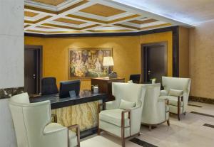 a waiting room with white chairs and a counter at Royal Maxim Palace Kempinski Cairo in Cairo +199 photos