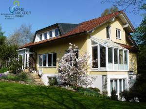 a yellow house with white windows and a yard at Ferienwohnung Ahorn Studio In Bad Dürrheim in Bad Dürrheim