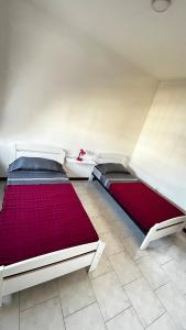 two beds in a room with red and white at Casa Fortes in Praia